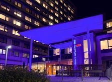 Ein Foto des lila angeleuchteten Hauptgebäude des Klinikums Hanau