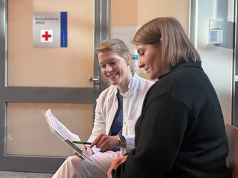In der Zentralen Notaufnahme des Klinikums Hanau bespricht Apothekerin Bianca Partheymüller mit einer Patientin den Medikationsplan. Sie sitzen in einem Behandlungsraum und gehen gemeinsam die eingenommenen Arzneimittel durch.